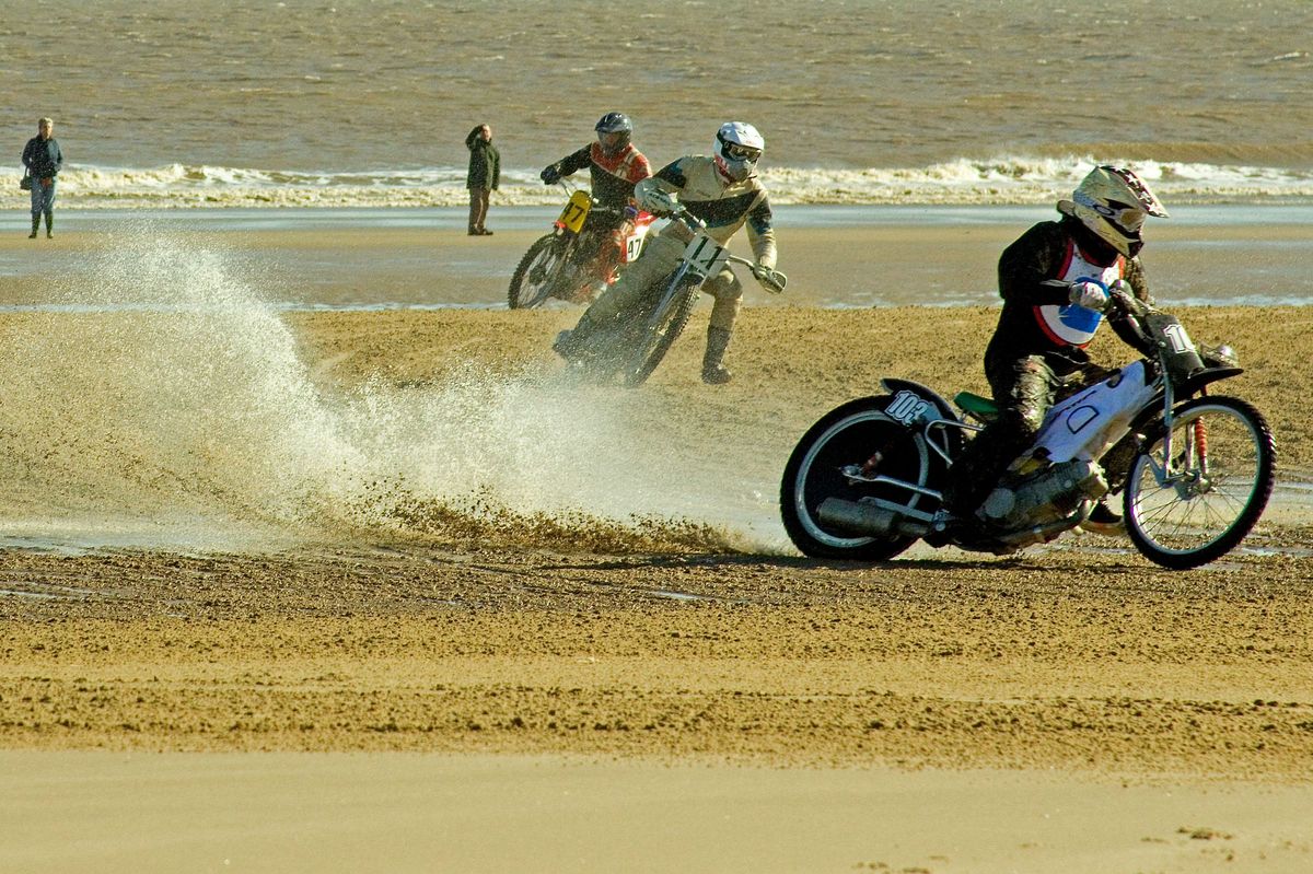 Motorbikes racing on the beach.